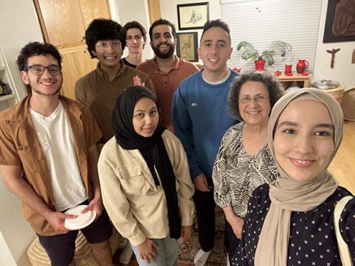 Suad Joseph surrounded by team of seven student researchers, all smiling