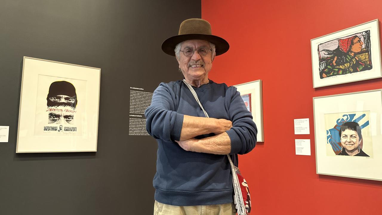 Malaquías Montoya is standing in front of his artwork at the Manetti Shrem Museum of Art