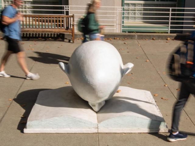 Egghead and a book outside Peter J Shields Library_feature