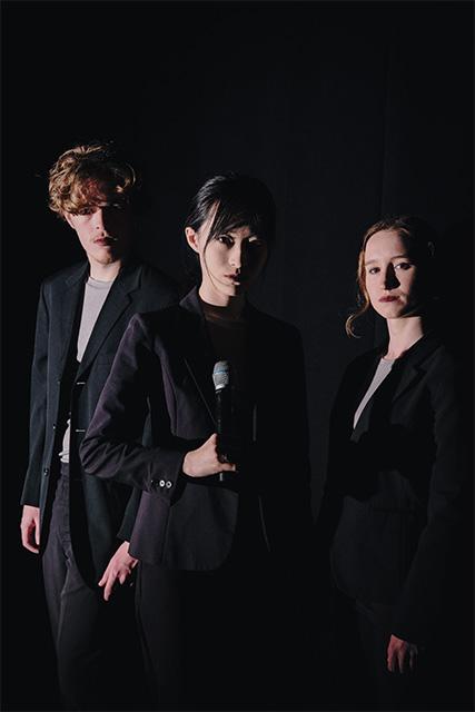 Peyton Harris, Noah Gu and Madeline Weissenberg are dramatically lit in this portrait for their shared portrayal of Hamlet