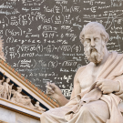 Sculpture of Greek philosopher Plato and Parthenon super-imposed on top of chalkboard with mathematical equations handwritten in chalk